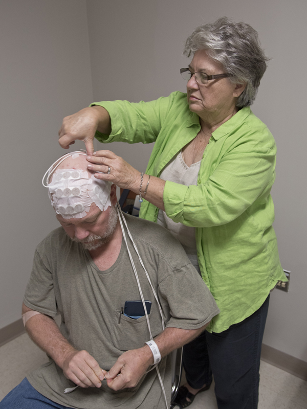 Newman's mother assists with placing the arrays after his recent checkup.