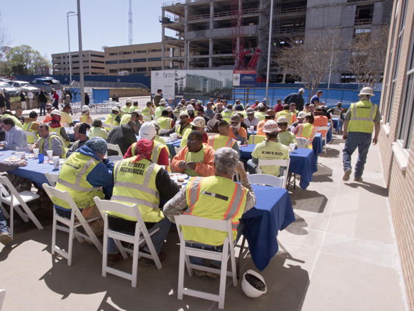 Members of the construction crew for Roy Anderson Corp. Contractors are treated to lunch during Monday's topping-out ceremony for the new School of Medicine building.