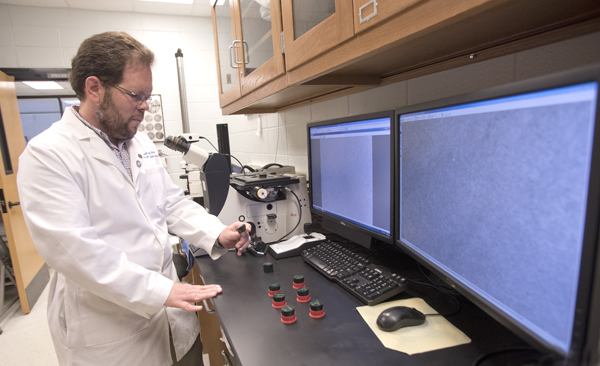 Dr. Michael Roach examines metallic microstructures in his laboratory.