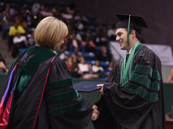 Zachary Johnson of Ocean Springs receives his Doctor of Medicine from Dr. LouAnn Woodward, vice chancellor for health affairs and dean of the School of Medicine.
