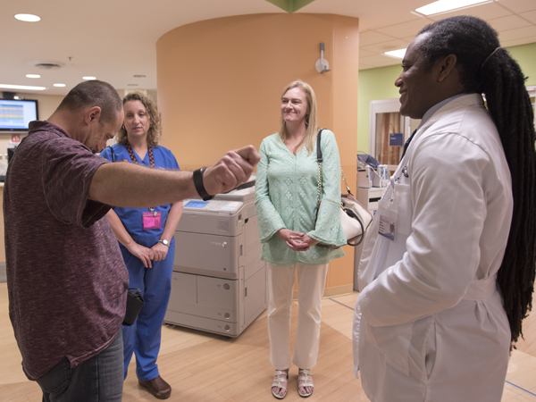 Canton resident David Lindsey, left, meets for the first time Dr. Catherine Faulk, second from left, and Dr. Michael Holder, both associate professors of pediatric emergency medicine, after they worked to save his life when he suffered a massive heart attack April 21. Also pictured is Lindsey's wife, Suzanne.