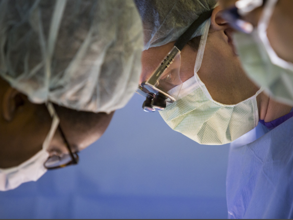 Dr. Kirsten Gambrell, left, and Orr work to remove tumors from Cook's abdomen.