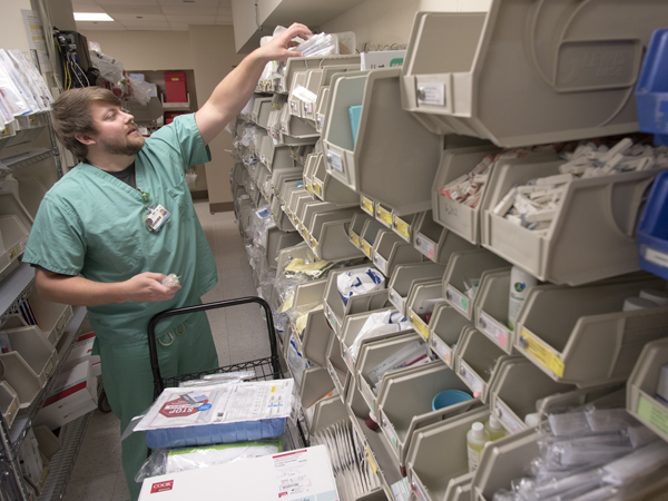 Matt Harris,, a registered nurse in the Medical ICU, stocks bins with supplies needed for critical care.