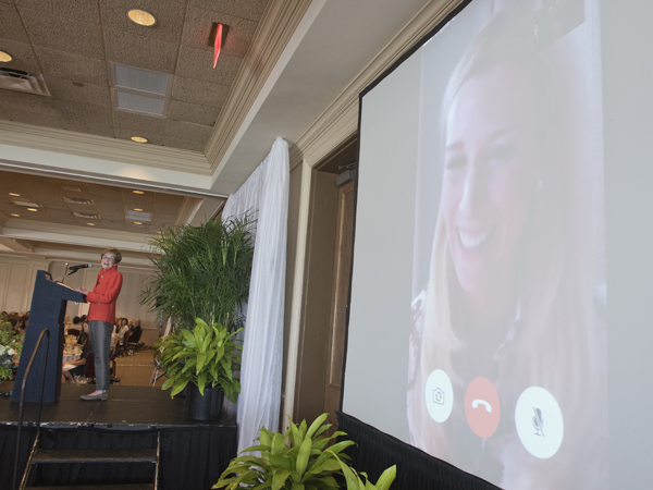 Children's of Mississippi capital campaign chair Kathy Sanderson, at the podium, chats with honorary campaign chair Abby Manning via FaceTime.