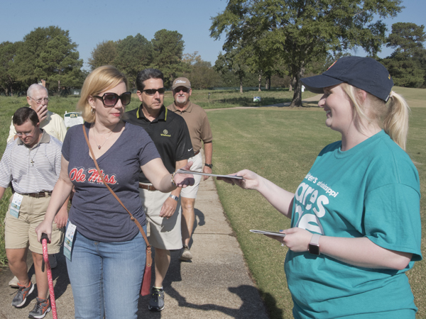 Aubree Jordan of Madison greets spectators with pairings guides as they head into the Sanderson Farms Championship, the state's only PGA TOUR event.