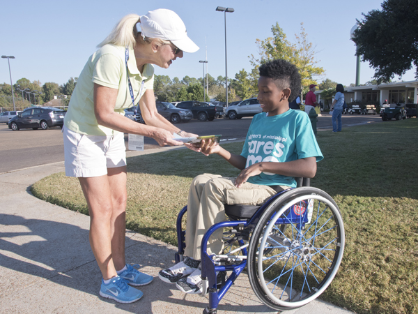 Diane Gribble of Dallas, mom of Sanderson Farms Championship winner Cody Gribble, meets another athlete: K.J. Fields of Mount Olive. K.J., though using a wheelchair, plays basketball, participates in track and field events and has even gone surfing. He was among greeters for Children's of Mississippi.