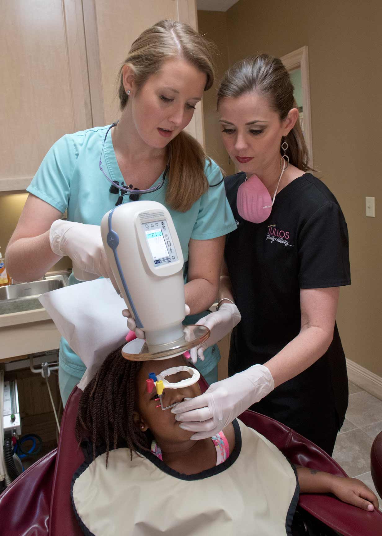 Howard, left, takes an x-ray of pediatric patient Kassidee Watson of Bay Springs as Tullos, left, assists.