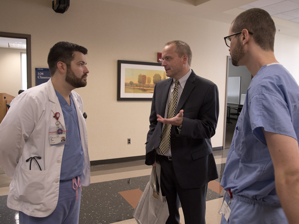 Prior to his address Wednesday for the Gay-Straight Alliance Lunch Lecture Series, Rob Hill, center, is welcomed by medical students Ian Taylor, left, GSA co-president, and Jimbo Dickerson.