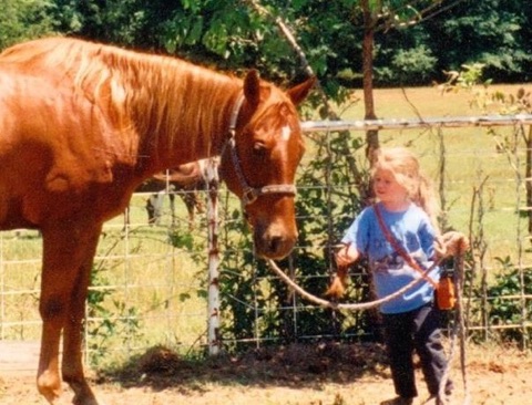 Dean, approximately 3 or 4 years old, holds the reins of her very first horse, Cowboy. Cowboy passed away on Monday, April 10.