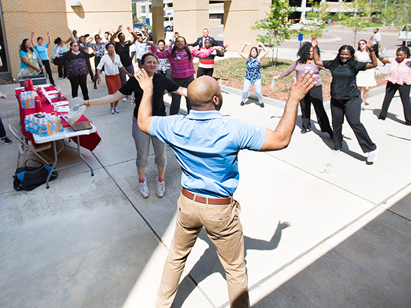 Ronald Woods, University Wellness medical integration coordinator, center, leads participants in warm-up exercises before taking a lap around the UMMC campus.