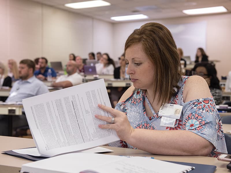 April Loftin, an enrollee in the School of Nursing's RN-BSN bridge program, dives into the paperwork during orientation.