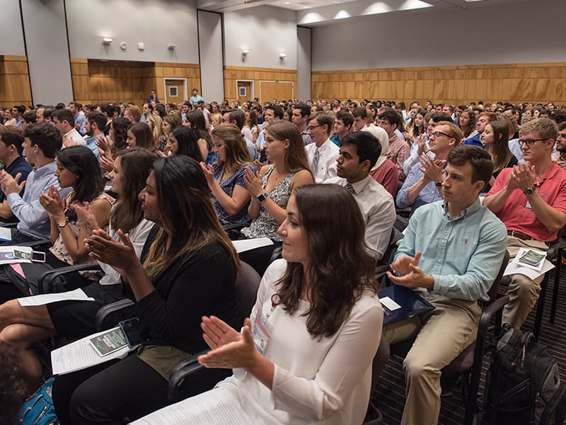 Students from the seven schools represented on campus respond to a speaker during an orientation assembly in the Student Union.