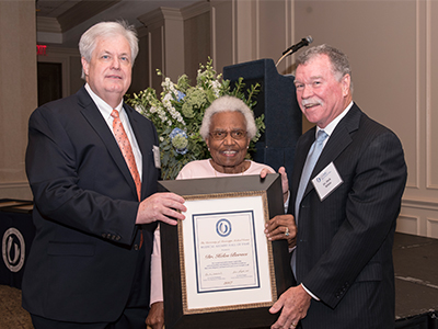 Barnes accepts her Hall of Fame certificate from Dr. Bruce Longest, left, president of the Medical Alumni Chapter and Dr. Charles White, who introduced her at the ceremony.