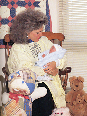 Rockin' Mamas project chair Pat Ammons rocks a NICU patient in 1989.