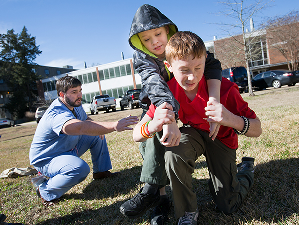 Bratton supervises as Ashland Clark, 12, of Raymond carries Timothy Pepper, 11, of Pearl to safety.