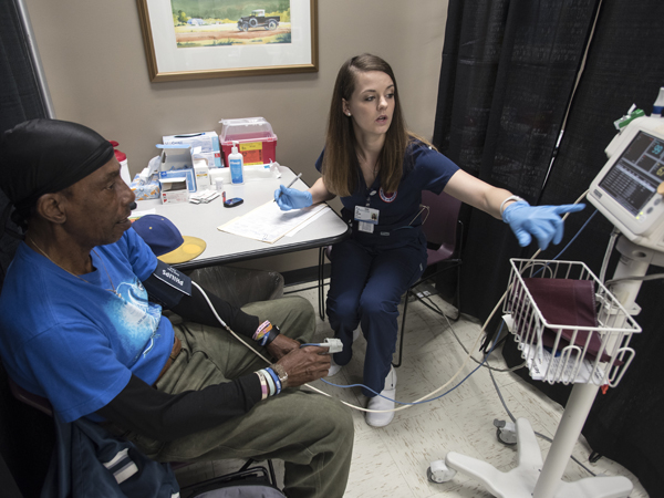 Junior nursing student Anne Sinclair checks the blood pressure of patient Thomas Murphy of Jackson.