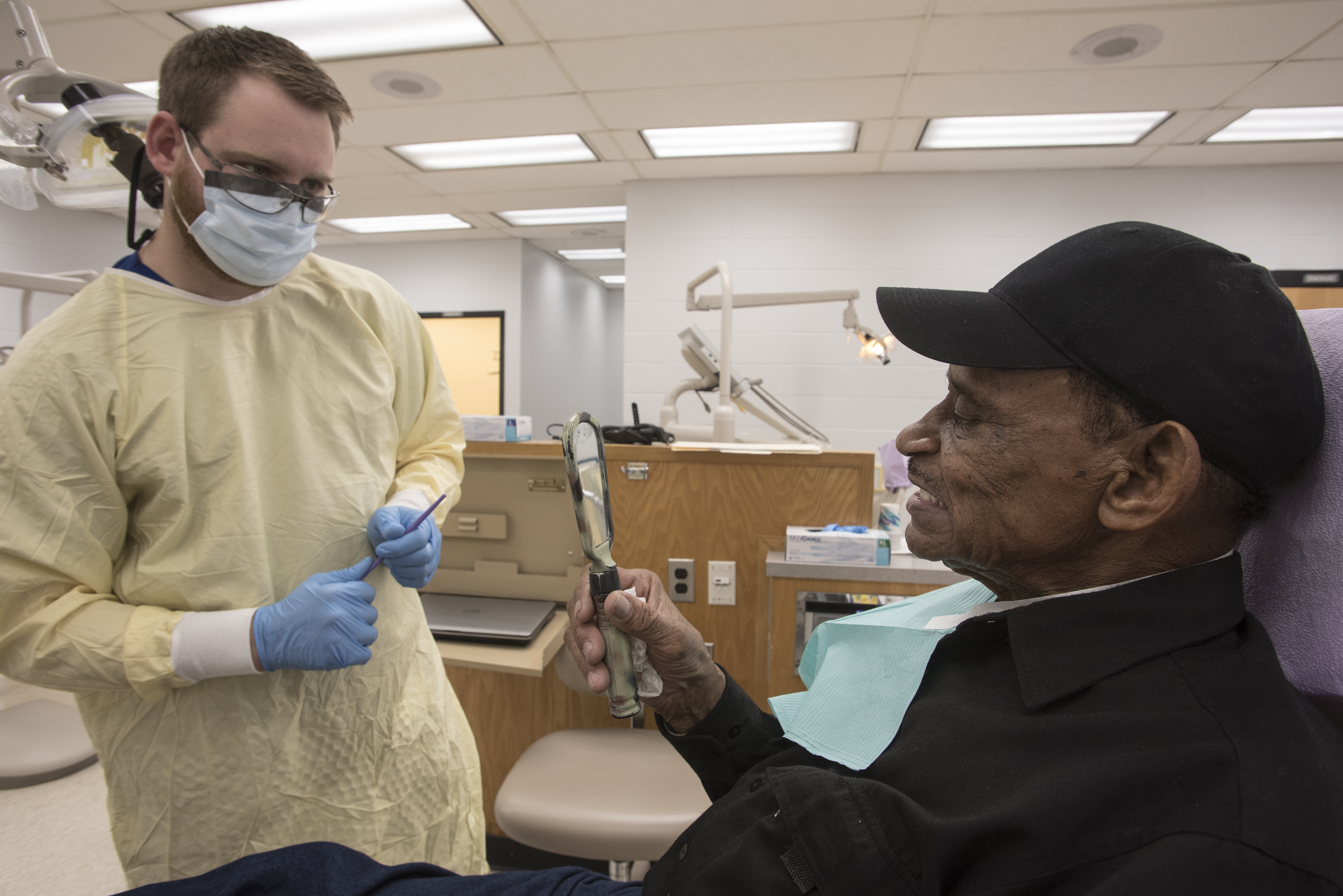 Glover, left, makes minor adjustments to Sutton's dentures during a fitting appointment on Wednesday.