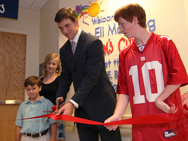 In 2009, Eli cuts the ribbon for the Eli Manning Children's Clinics with help from Batson Children's Hospital patients, from left, Cameron Smyly, Aubree Jordan and Taylor Gibson.