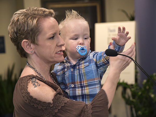 Two-year-old Jack Reynolds reaches for the microphone as mom Morgan Strickland tells of the importance of neonatal transport to her family.