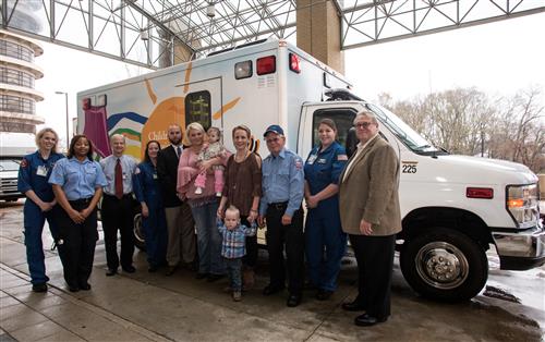 Celebrating the commissioning of a new AMR neonatal ambulance for Batson Children's Hospital are, from left, nurse Emily Jones, AMR driver Cassetta McGee, neonatal transport team medical director Dr. Kelly Hersey, nurse Kathy Hamilton, UMMC neonatal and pediatric transport manager Stephen Houck, Kristie Benson and daughter Paisley, Morgan Strickland and son Jack Reynolds, AMR driver Robert Whitley, nurse Lauren Russell and AMR public affairs manager Jim Pollard.
