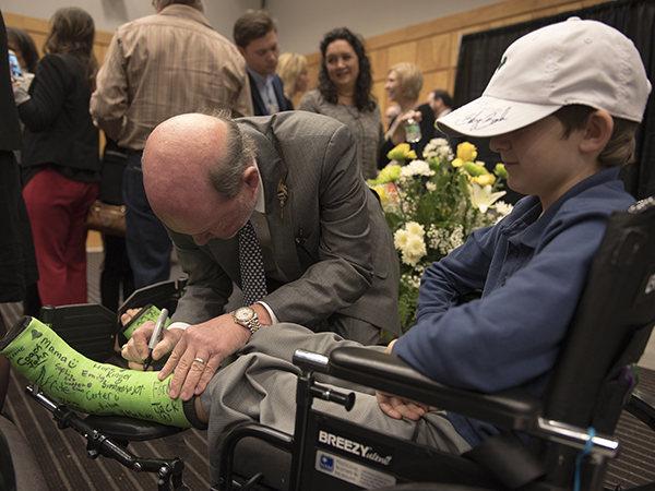 Sanderson signs the bright green cast of Walker.