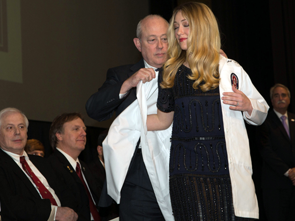 Mary Caskey Ousley of Jackson is coated by her father, Dr. Charles Caskey, associate professor of dentistry in the Department of Periodontics and Preventative Dentistry. Mary's brother, Curtis, and her father are both School of Dentistry alumni.