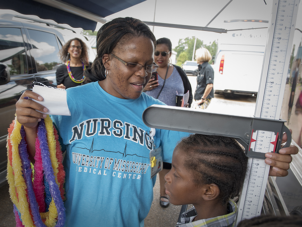 Ramona Brock, a licensed practical nurse with the School of Nursing's Delta schoo-based clinics, checks the height of George Gilliam of Jonestown.