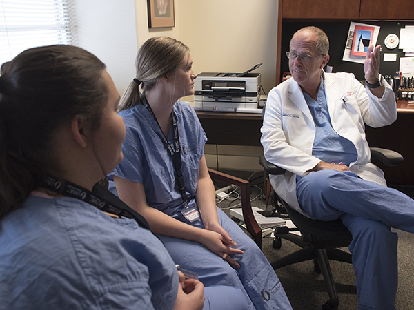 Dr. James J. Wynn, professor of transplant surgery, shares transplant surgery insights with Howell, left, and Blaylock.
