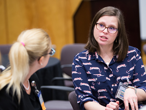 Dr. Victoria Gonzalez, right, assistant professor of otolaryngology and communicative sciences, talks with a colleague during the workshop.