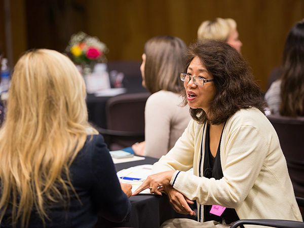 Dr. Dongmei Cui, right, assistant professor of neurobiology and anatomical science, takes part in a negotiation exercise.