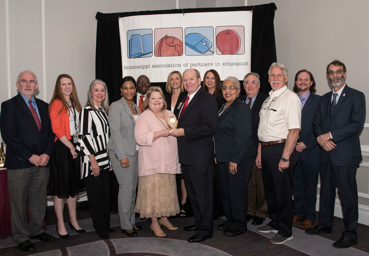 Representatives from six UMMC schools accept the Partnership Excellence Award from Jackson Public Schools officials. Participants in the ceremony include, from left, Dr. Steve Watson, representing the School of Health Related Professions; Dr. Sydney Murphy, representing the School of Graduate Studies in the Health Sciences; Dr. Janet Harris, representing the School of Nursing; Dr. Michelle King, representing Jackson Public Schools Elementary; Dr. Claude Brunson, representing the School of Medicine; Tammy Dempsey, representing UMMC Academic Affairs; Dr. Kim Hoover, representing the School of Nursing; Phil Hardwick, representing the Mississippi Association of Partners in Education; Dr. Leigh Ann Ross, representing the School of Pharmacy; Thea Faulkner, representing Jackson Public Schools Partners in Education; Dr. Ralph Didlake, representing the School of Medicine; Dr. William Duncon, representing the School of Dentistry; Dr. David Norris, representing the School of Medicine; and Dr. Rob Rockhold, representing UMMC Academic Affairs.