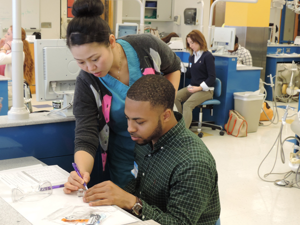 Nunnery, right, is assisted by former student Kefei Duan during the 2014 SNDA Impressions Program.