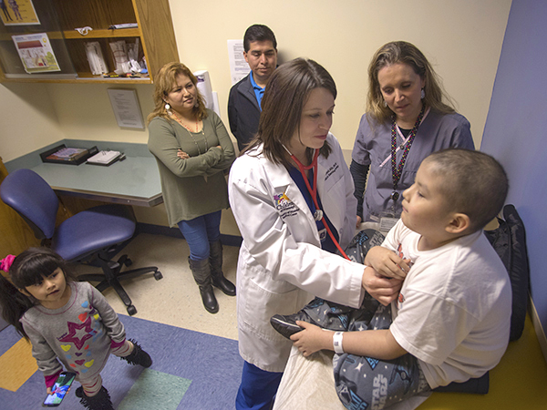 The Martinez family, from left, Hillary, Nicolasa and Miguel are attentive as Angel, right, is examined by nurse practitioner Tobi Breland; standing by is medical interpreter Nicole Marr.