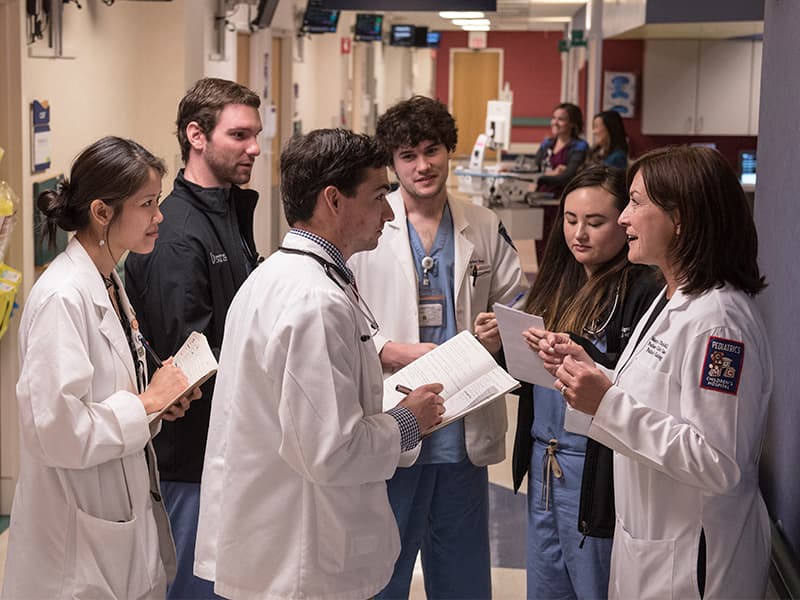 n her role as chair of the Department of Pediatrics, Taylor, right, also leads educational efforts. Here, she takes a group of medical learners, from left, Anne Folks, John Weldy, Griffin Metcalf, Stephen Stone and Bridgett Cheng on rounds at Batson Children's Hospital.