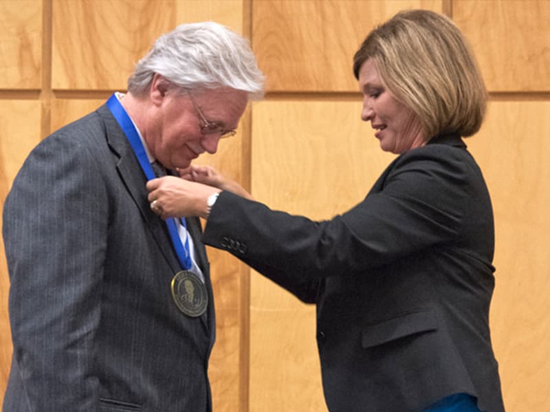 Dr. LouAnn Woodward, right, vice chancellor for health affairs and dean of the school of medicine, awards the Billy S. Guyton Distinguished Professor medallion to Dr. Richard Summers in June 2015.