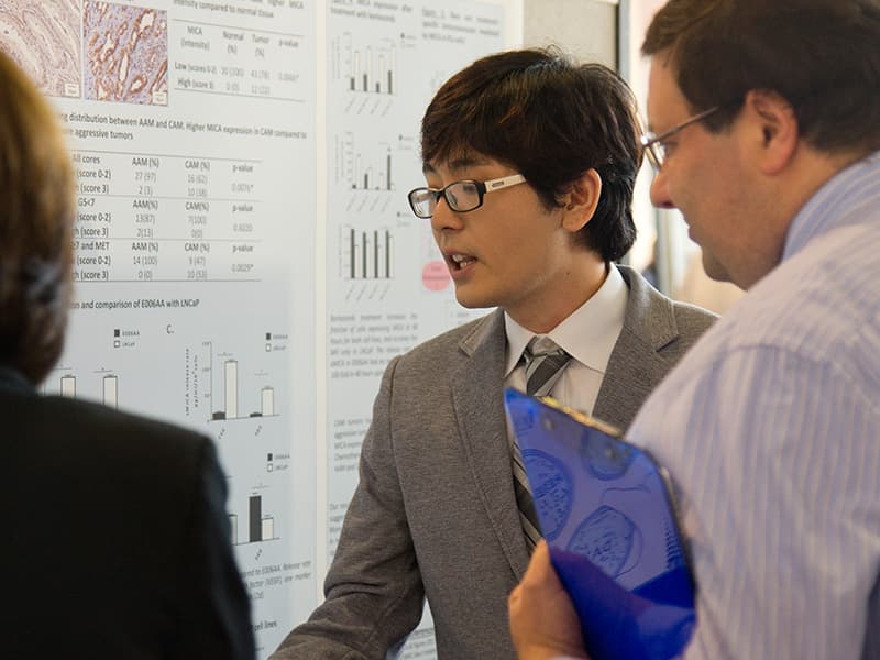 Marcelo Sakiyama, a fourth-year Ph.D. student in Pathology, shares his research with Dr. Damian Romero, assistant professor of biochemistry.