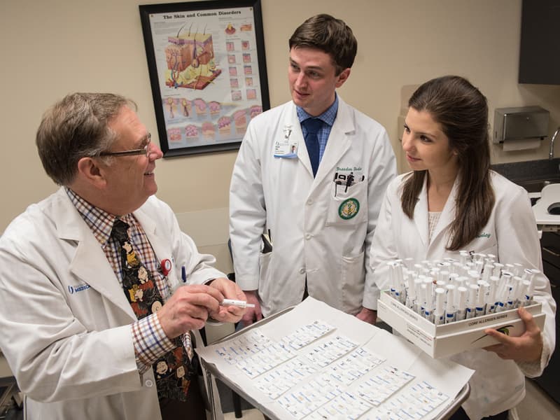 Dr. Stephen Helms, professor of dermatology, teaches a patch-testing technique to detect substances that cause allergic contact dermatitis to medical students Brandon Bodie and Jordan Keely, both in their fourth year at the University of Alabama-Birmingham.
