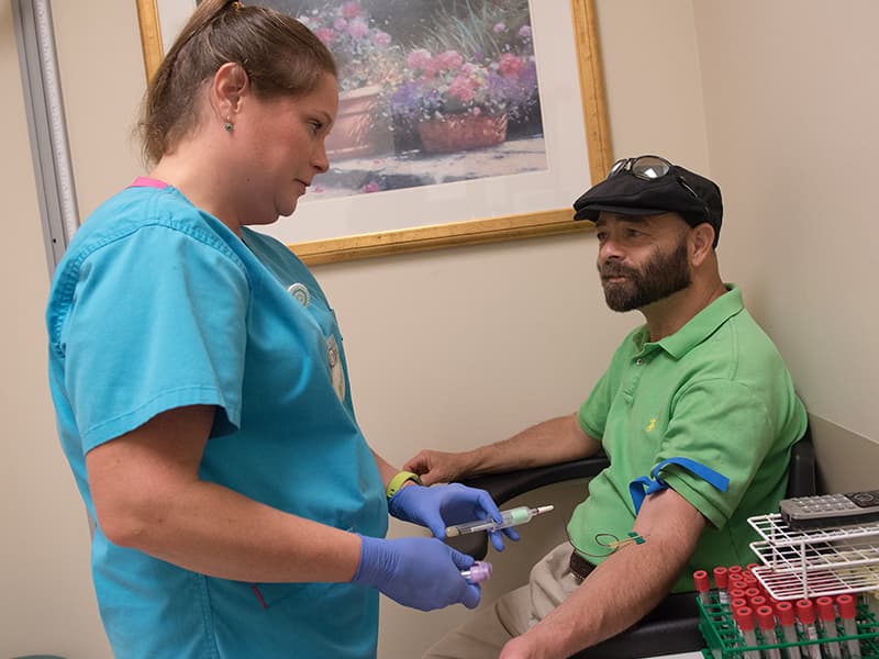 Leah Creel, a technician in the abdominal transplant clinic, draws a blood sample from Murphree.