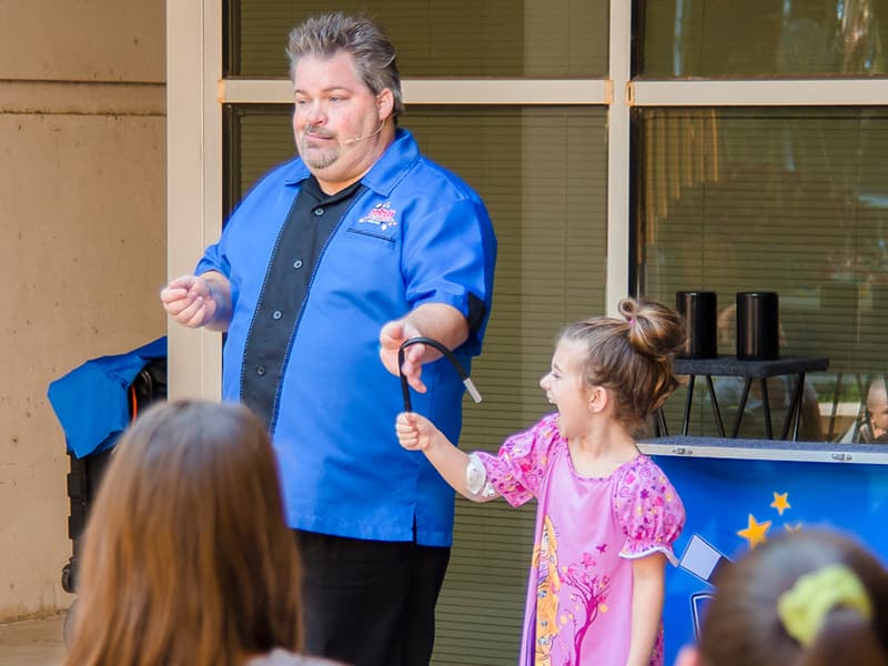 Dorian LaChance's magic trick gets a laugh from assistant Emma Reynolds of Petal, a Batson Children's Hospital patient.