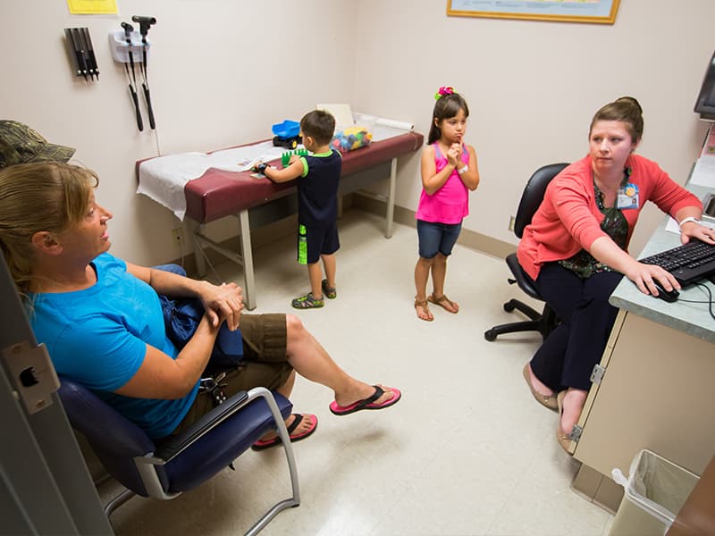 Saunders gets an update from Pearlie Warren, foreground, left, legal guardian of patients John Wesley Bishop, background, left, and his sister Lana Puga.