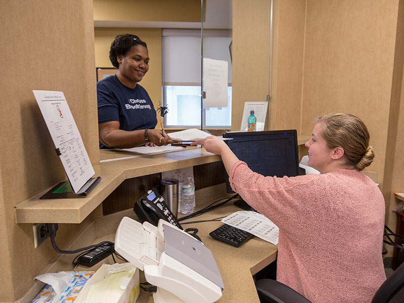 Patient Nikki McInnis of Jackson, left, is checked in for her appointment in the Department of Family Medicine by administrative assistant April Little.