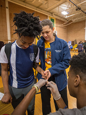 Josie Bidwell gives Kevin Fox moral support as he gets a blood glucose screening from Keyontravious Thompson.