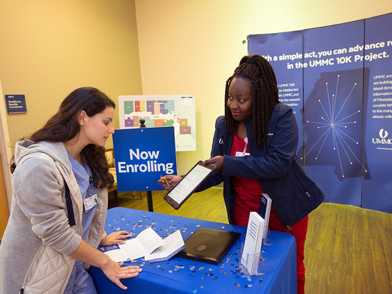 Employee Maria Carrillo, left, registers for the UMMC 10K Project with the aid of Jacquelyn Collins.