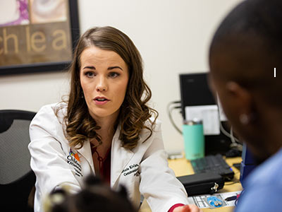 Audiologist Dr. Victoria Kivlan talks with Kadence Lane's family during the cochlear implant activation.