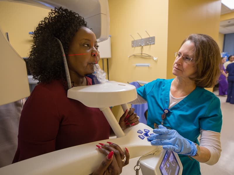 Dental assistant Susan Miley takes a radiograph of Johnson's mouth during a recent checkup at UMMC's Oral Oncology Clinic.