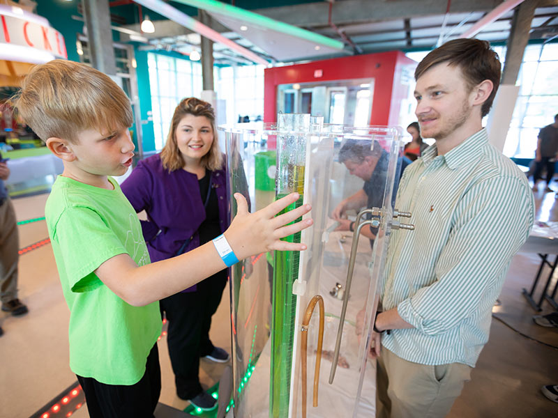 Biomedical materials science Ph.D. student Jared Cobb gives Northshore Elementary student Brooks Harrison a lesson on viscosity.