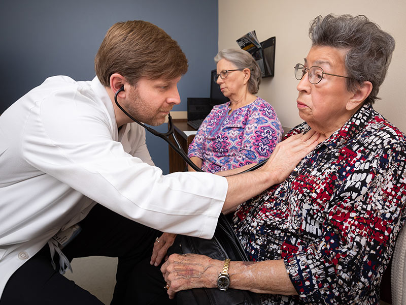 Dr. John Parks examines Dudley a month after her procedure. Accompanying Dudley on her follow-up appointment is Patsy Hammack of Vicksburg.