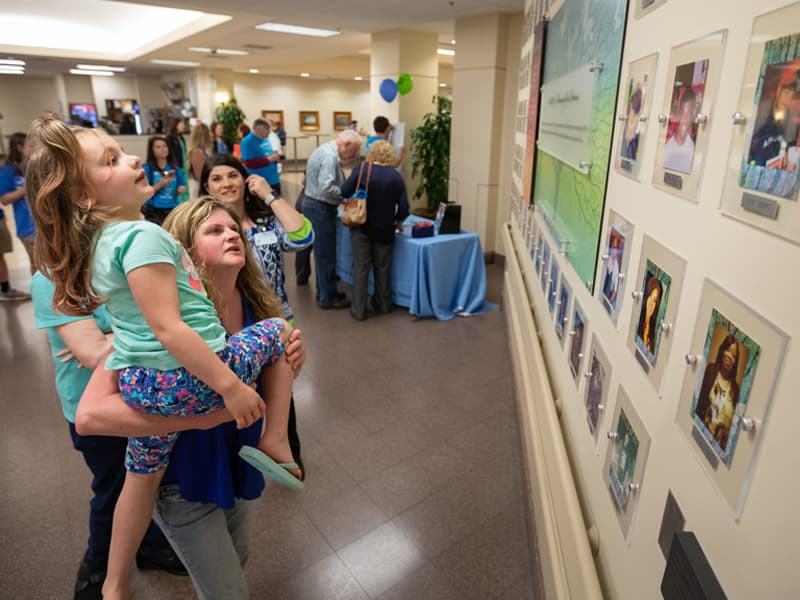 Christina Jordan of Tupelo holds up her granddaughter, Elinor Steward, so that she can see the photo of her father and Jordan's son, Gabriel Jordan. Christina Jordan donated Gabriel's organs following his death in September 2014.