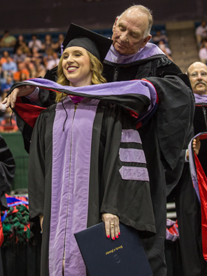 Mary Catherine Hoover is hooded by her Dad, Dr. Dennis Hoover.