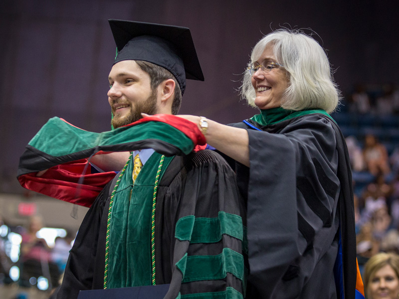 New School of Medicine graduate Stephen Wahl is hooded by his mother, Dr. Nancy Wahl, associate professor of pediatric emergency medicine.